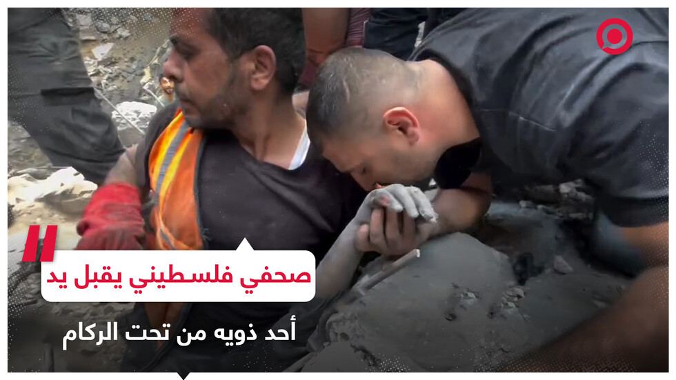 صحفي فلسطيني يقبل يد قريبه تحت الأنقاض