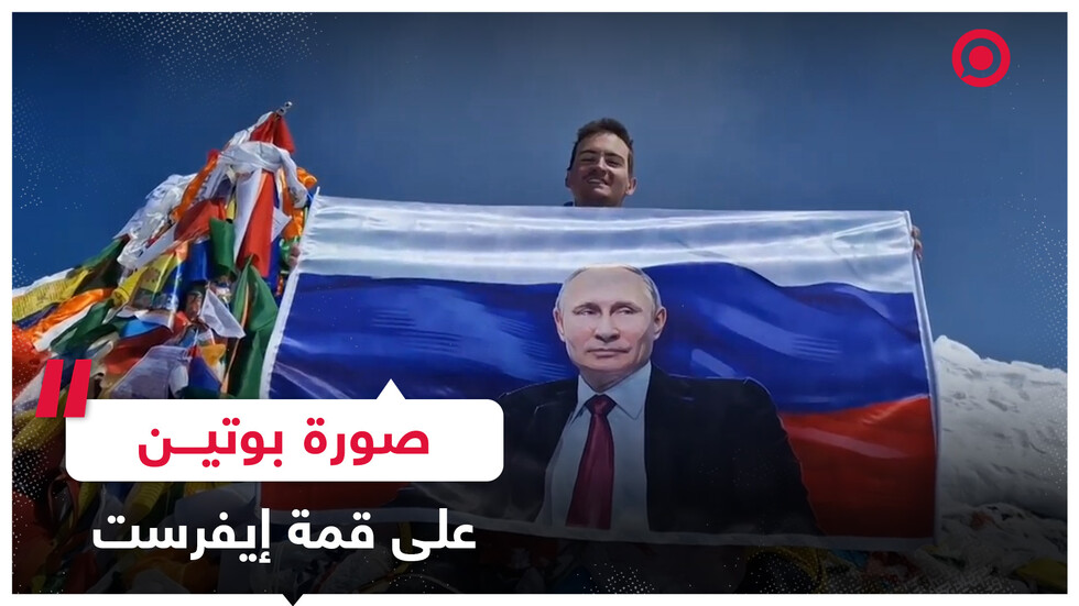 العلم الروسي وصورة بوتين يرفرفان عاليا على قمة جبل إيفريست
