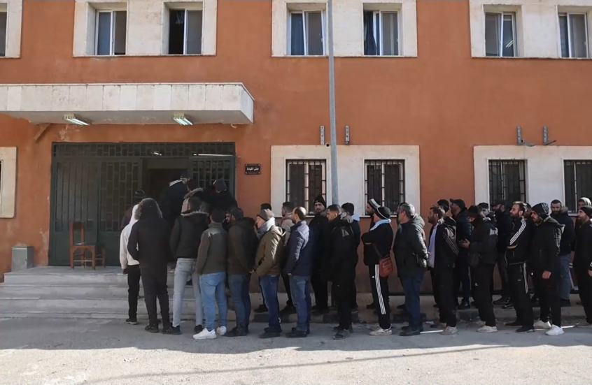 جنود من الجيش السوري يصطفون لتسوية أوضاعهم مع الحكومة المؤقتة الجديدة