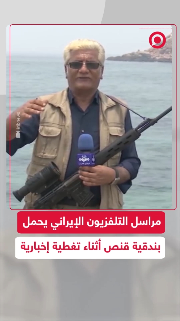 مراسل التلفزيون الإيراني يقدّم تقريرا حاملا بندقية قنص قرب مضيق هرمز