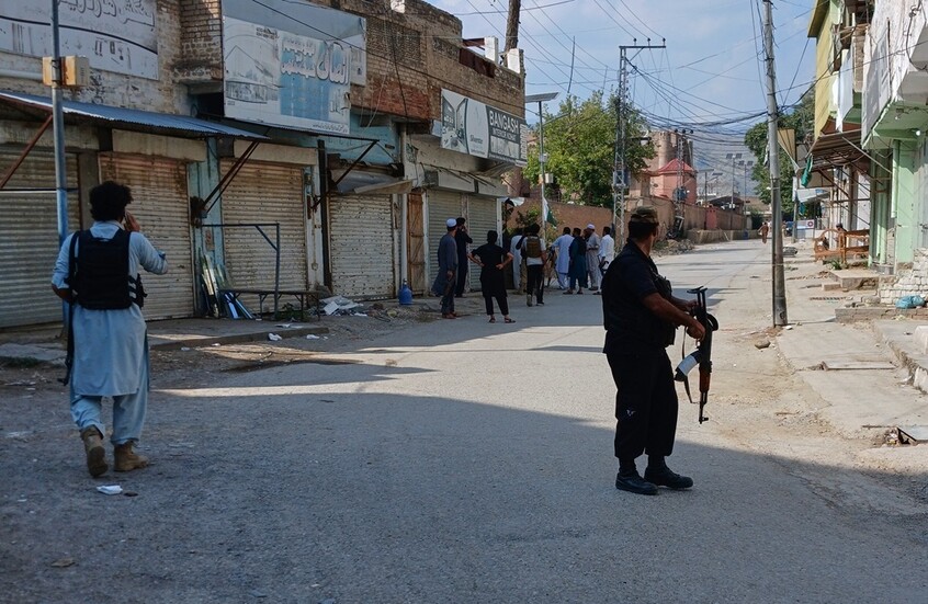 اضباط شرطة يقومون بتأمين الطريق المؤدي إلى موقع انفجار قوي في مسجد بكوهات الباكستانية