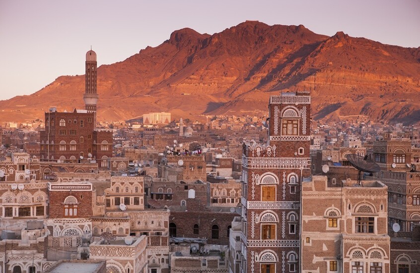 مشهد بانورامي لأسطح المباني التاريخية في صنعاء القديمة وقت الغروب
