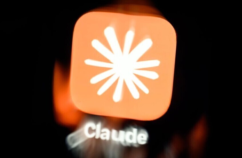 صورة لأيقونة تطبيق الذكاء الاصطناعي Claude من شركة Anthropic معروضة على شاشة رقمية مع خلفية سوداء