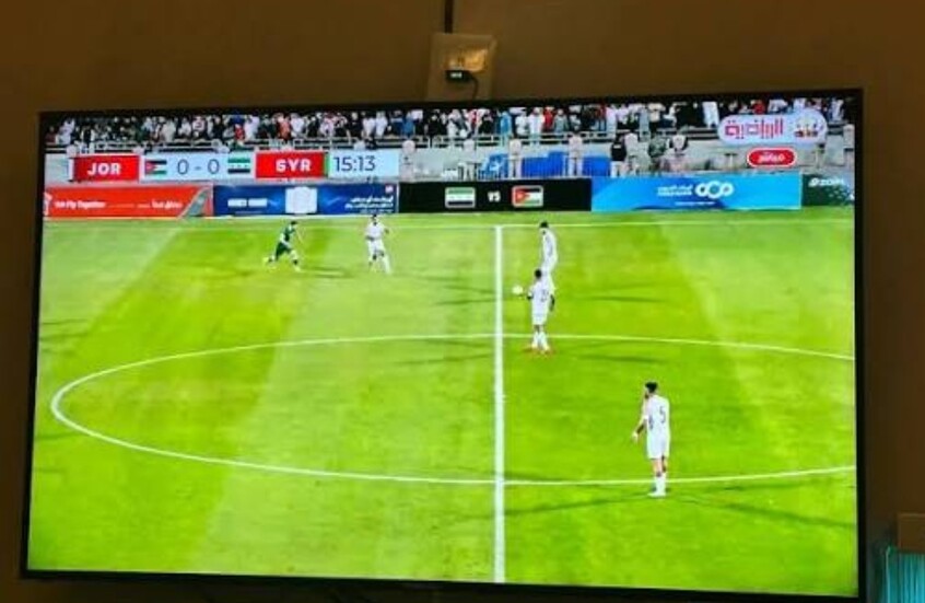 شاشة تلفاز تبث المباراة الودية بين منتخبي سوريا والأردن والتي انتهت بالتعادل 1-1