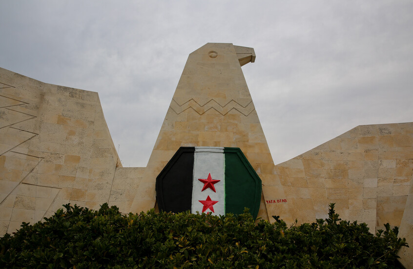 علم سوريا على جدار في مدينة حماة