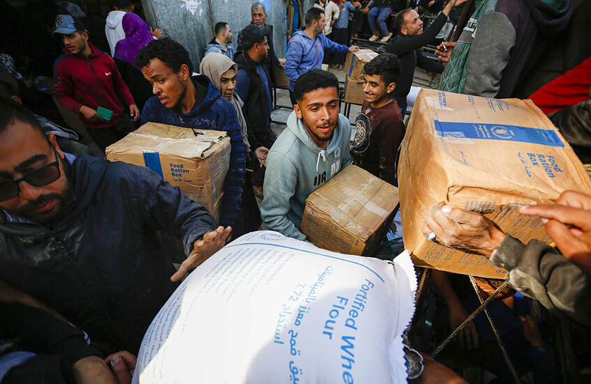 فلسطينيون نازحون، بينهم أطفال، يتسلمون الدقيق وطروداً غذائية وزعها برنامج الأغذية العالمي التابع للأمم المتحدة في منطقة الزوايدة بدير البلح وسط قطاع غزة، وذلك في 7 يناير/كانون الثاني 2026.